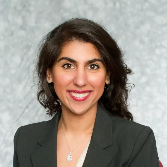 a woman in a suit smiling for the camera